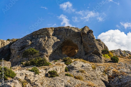 Cape Alchak on southern coast of Crimea on  outskirts of resort town of Sudak. Fabulous view of big mountain with Aeolian harp grotto on Alchak-Kaya trail. Close-up of huge stones and natural boulders © AlexanderDenisenko