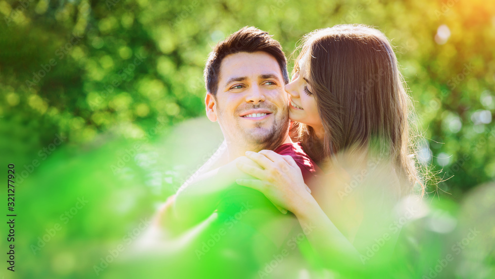 Young, happy couple is enjoying the sun in the green Young, happy couple is enjoying the sun in the green