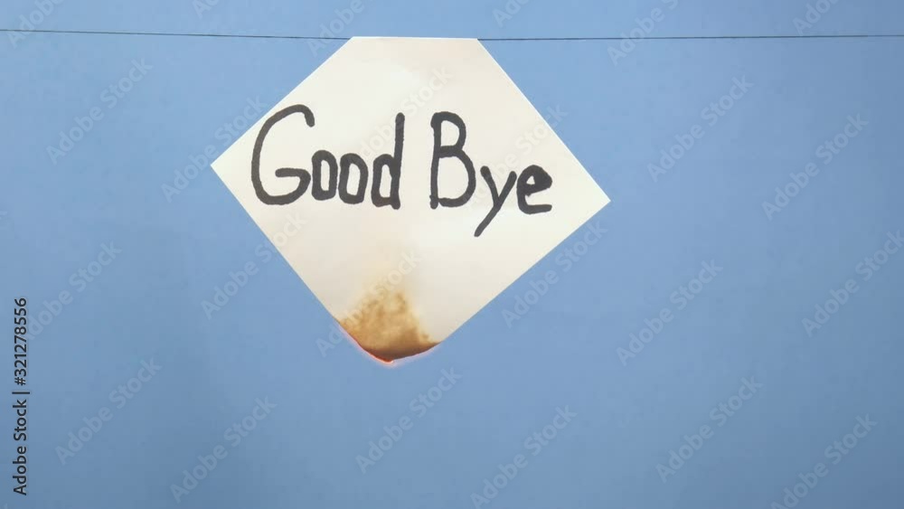 Burning and smoking white sheet of paper with a black inscription 