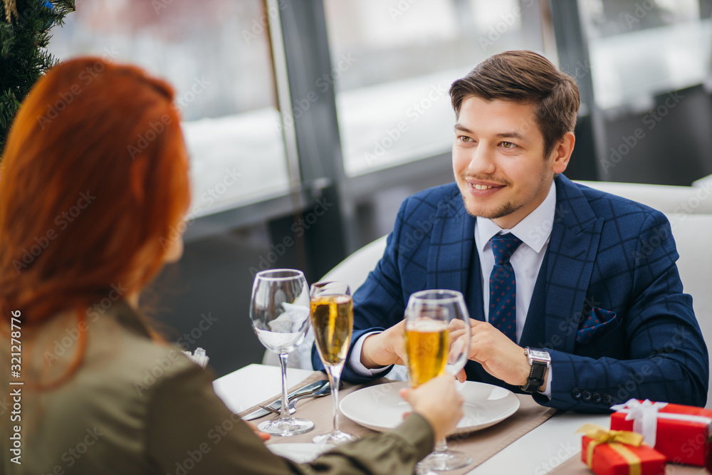 romantic pastime of young beautiful caucasian couple in restaurant. redhaired attractive lady and handsome bearded man in tuxedo on a date. tender relationship between two people in love romantic pastime of young beautiful caucasian couple in restaurant. redhaired attractive lady and handsome bearded man in tuxedo on a date. tender relationship between two people in love