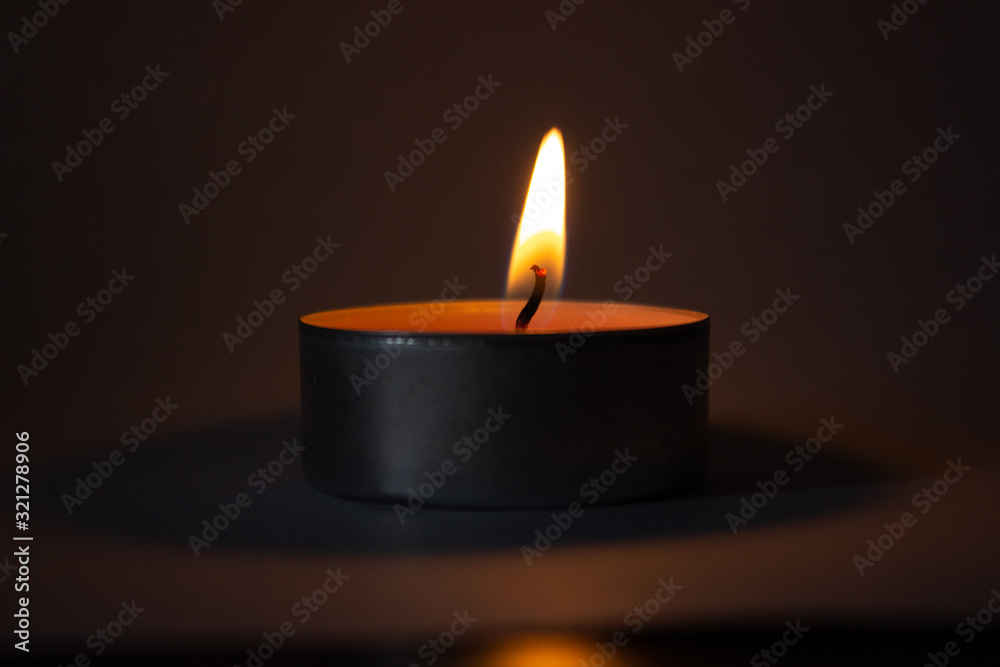 Candle on dark luxury night background. Black table, side view. Candles Burning at Night. Orange taper burning in focus, foreground. illustration design. Candle on dark luxury night background. Black table, side view. Candles Burning at Night. Orange taper burning in focus, foreground. illustration design.