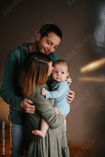 Portrait of a young happy family with the kid. Beautiful family hugs