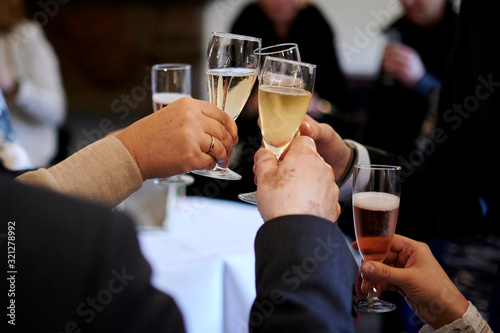 Hände stoßen auf einer Hochzeit mit Sekt an photo