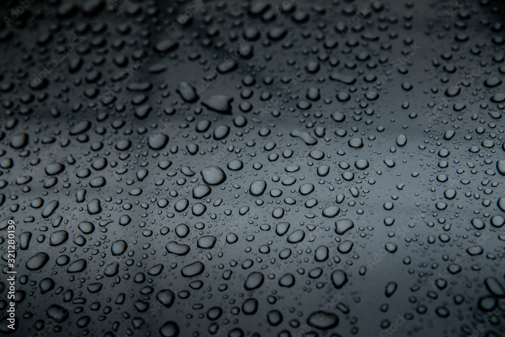  hundreds and thousands of beaded water droplets on a gloss black surface