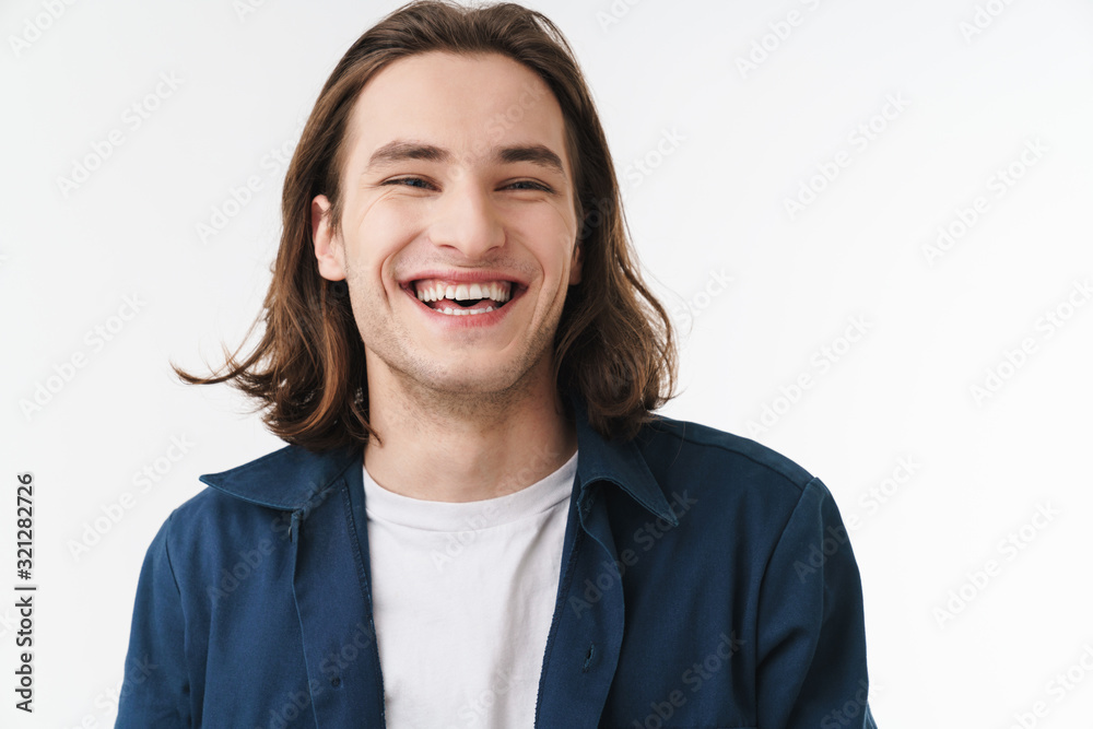 Image of joyful young man laughing and looking at camera Image of joyful young man laughing and looking at camera
