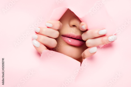 young woman with pink lips in torn paper photo