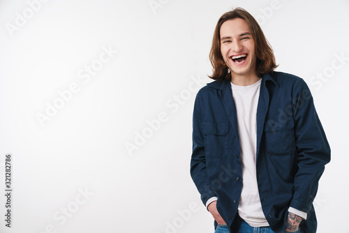 Image of joyful young man laughing and looking at camera