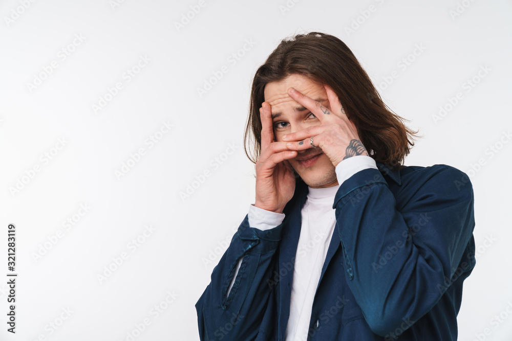Image of scared young man looking at camera and covering his face Image of scared young man looking at camera and covering his face