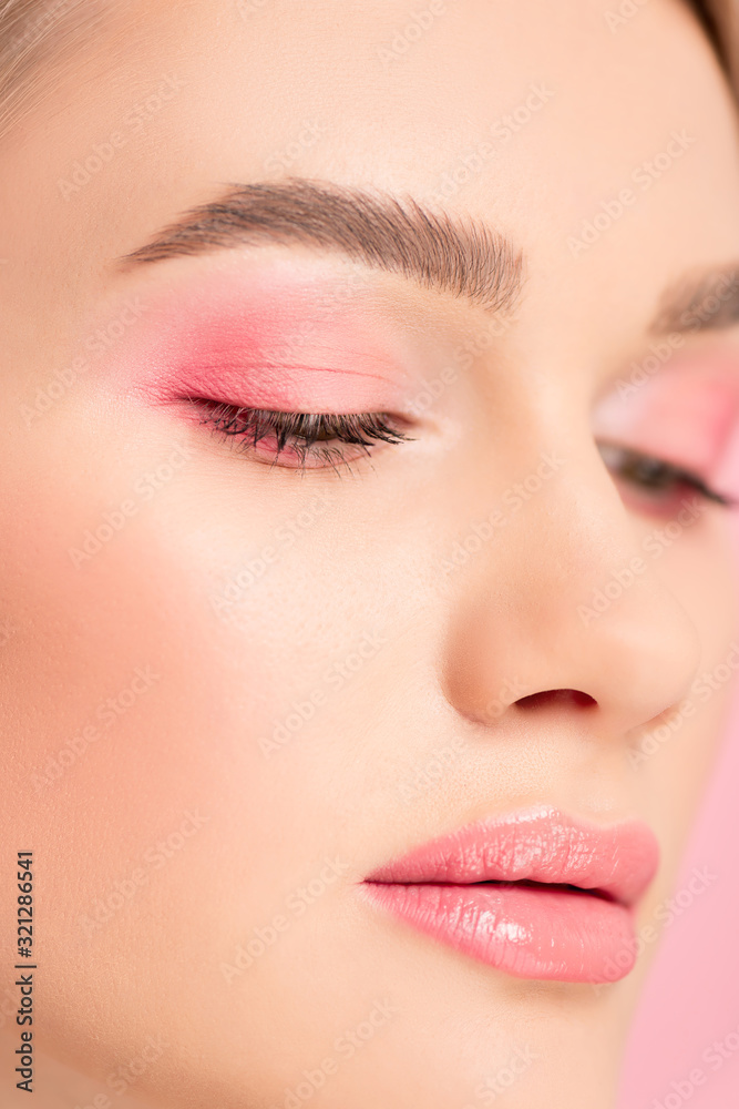 close up of attractive girl with pink makeup, isolated on pink