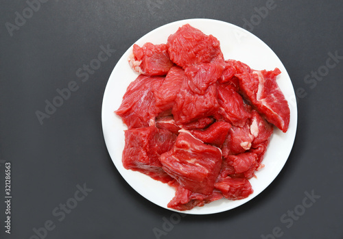 Raw red meat on black background.