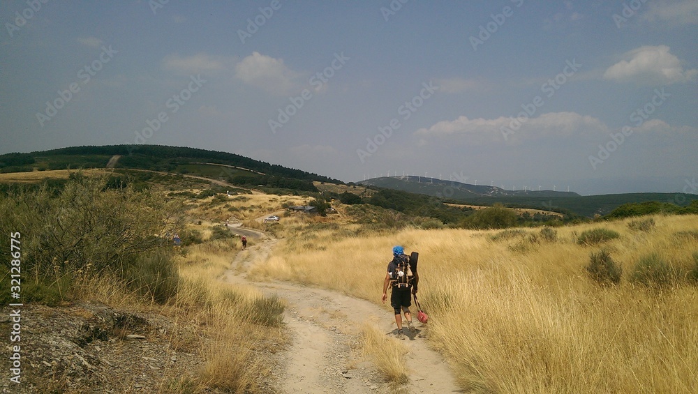 Pilgrims walking on the way of St James, the Pilgrimage of Compostela, camino de santiago, Spain. Fields of wheat 
