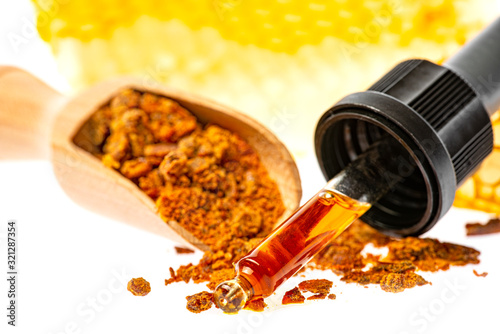 Tableau sur toile propolis tincture and a wooden spoon of propolis granules