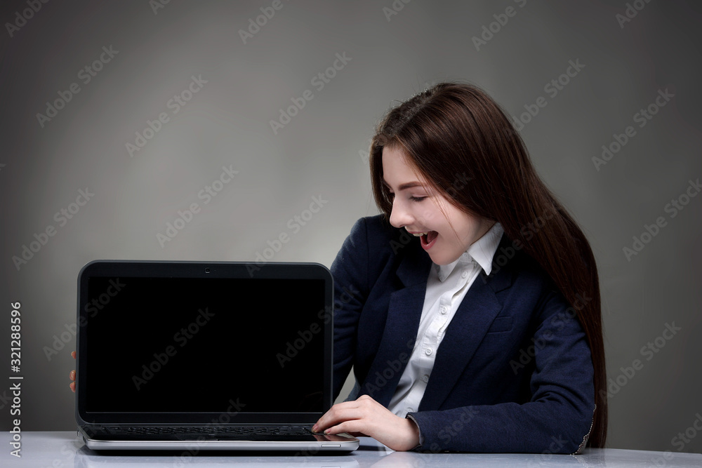 Pretty teen girl sitting at table with laptop.Surfing the NET Pretty teen girl sitting at table with laptop.Surfing the NET