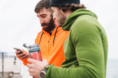 Two confident young sportsmen resting after work out