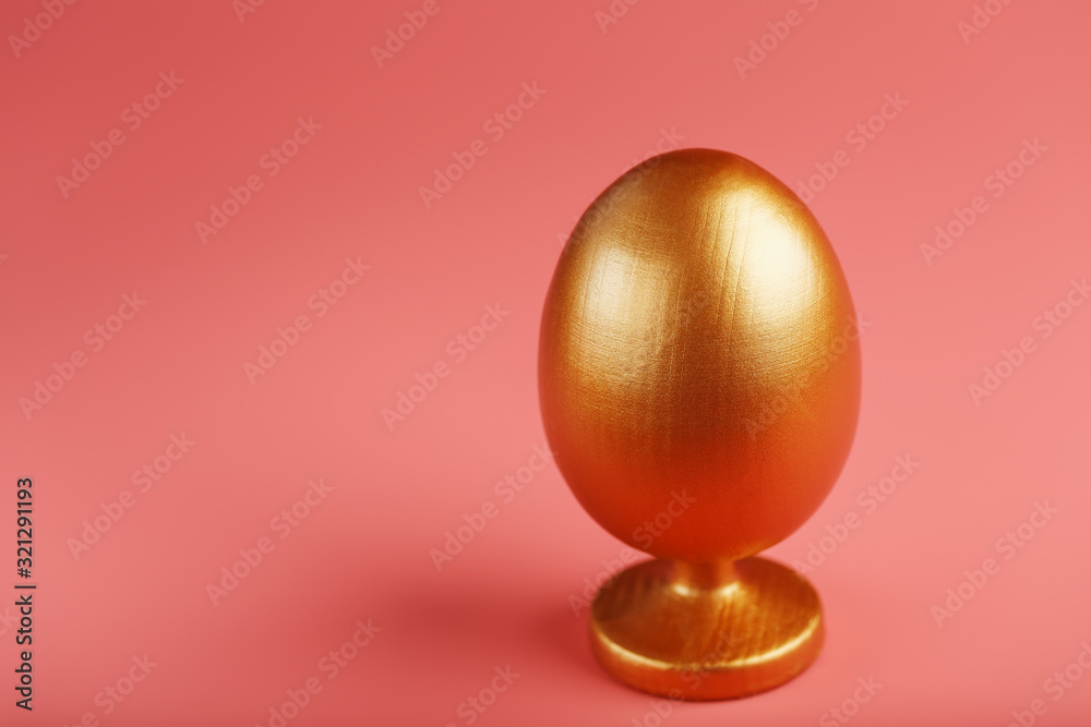 Golden egg on a pink background with a minimalistic concept. Golden egg on a pink background with a minimalistic concept.