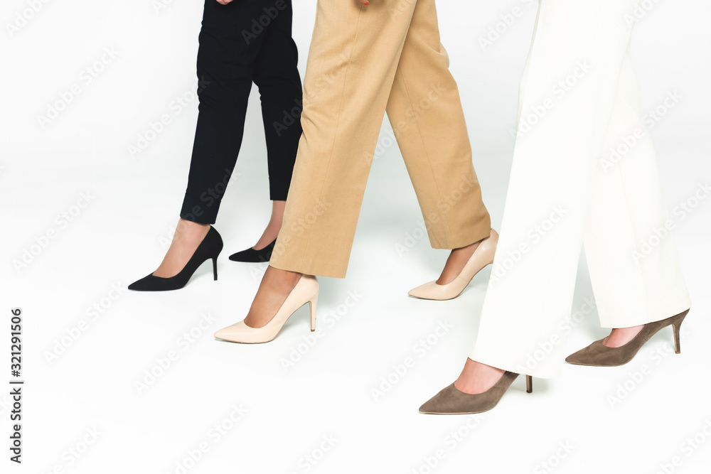 cropped view of multicultural businesswoman walking on white