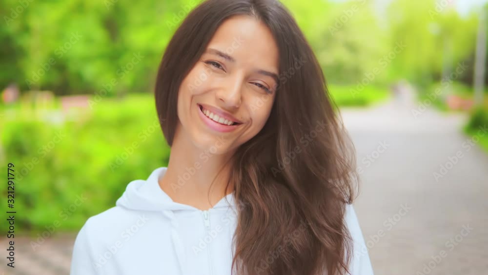 portrait of a cheerful girl laughing happily looking into the camera woman wearing white casual hoodie showing positive emotions on the street portrait of a cheerful girl laughing happily looking into the camera woman wearing white casual hoodie showing positive emotions on the street