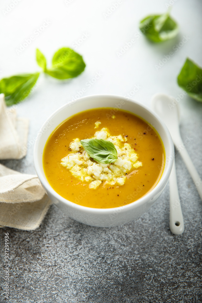 Homemade carrot pumpkin soup with cheese and basil Homemade carrot pumpkin soup with cheese and basil