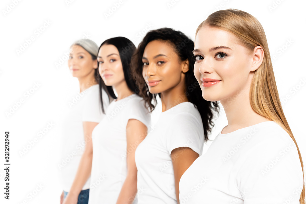 selective focus of four multicultural women in white t-shirts looking at camera isolated on white selective focus of four multicultural women in white t-shirts looking at camera isolated on white
