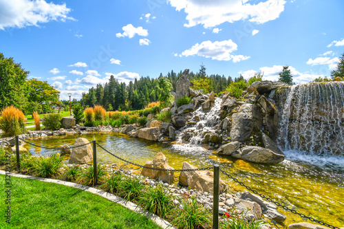 Colorful landscaping at a public waterfall and pond near the McEuen Park area of the resort mountain town of Coeur d'Alene, Idaho, USA photo