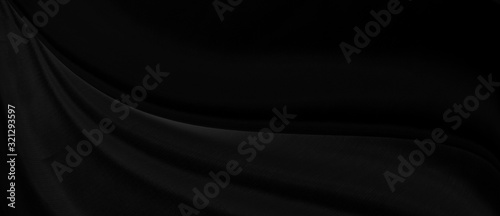 Black gray satin dark fabric texture luxurious shiny that is abstract silk cloth panorama background with patterns soft waves blur beautiful.