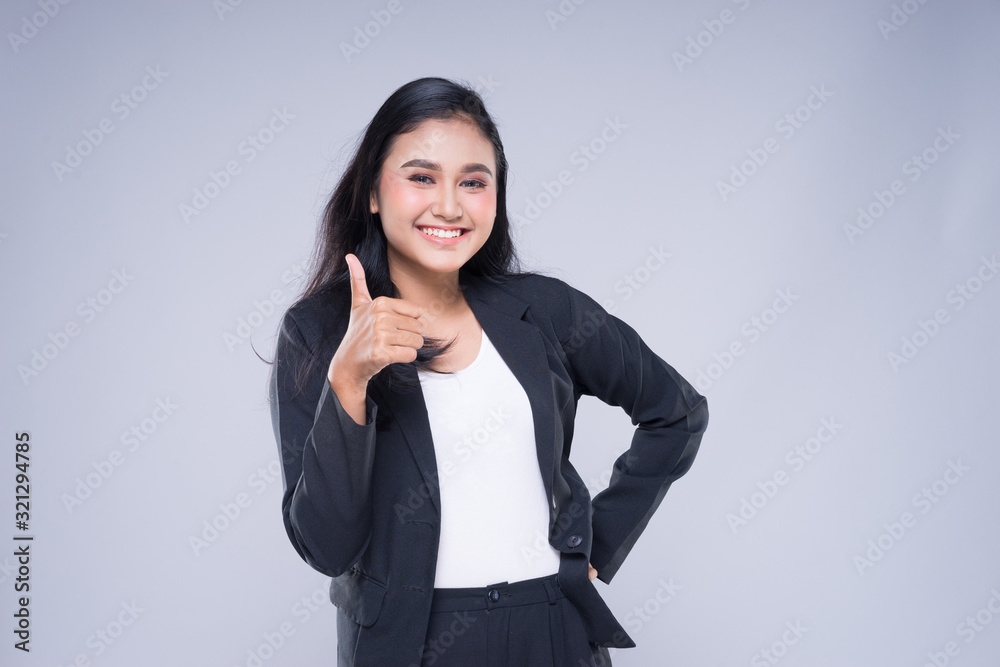 An attractive woman wearing business attire with gestures towards copyspace area isolated on grey. Good for manipulation works for technology, transportation, business or finance theme. An attractive woman wearing business attire with gestures towards copyspace area isolated on grey. Good for manipulation works for technology, transportation, business or finance theme.