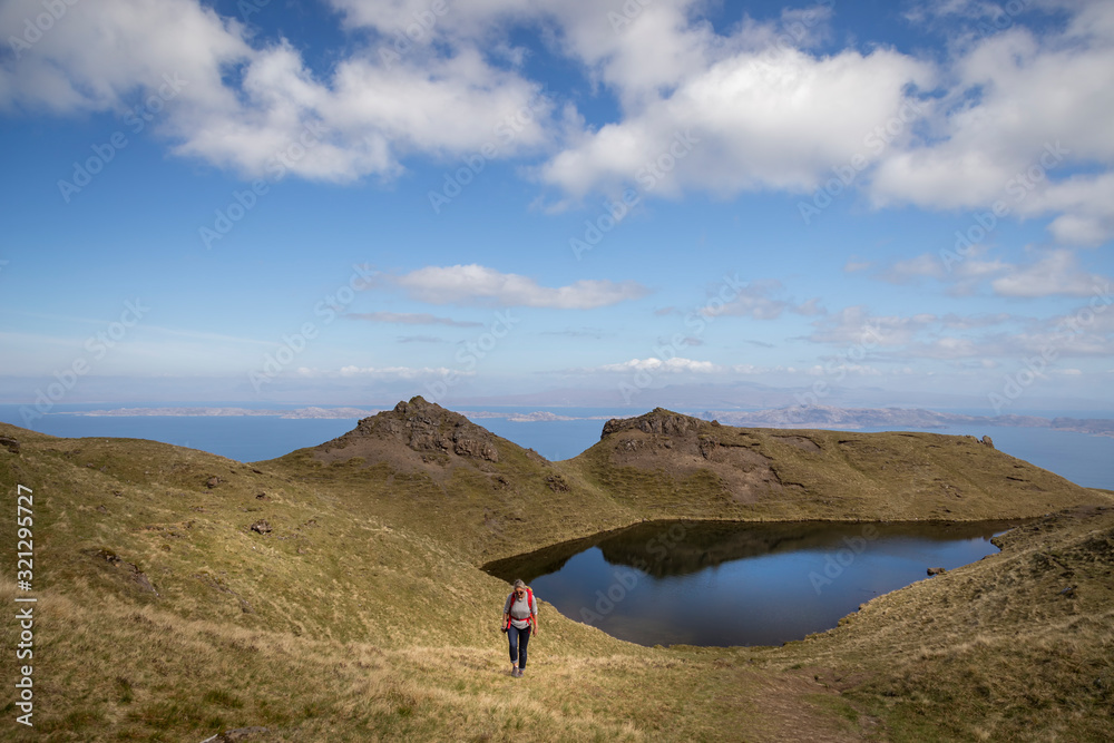 woman trekking up to old man of storr on skye