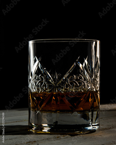 Bottle and glass of whiskey jn the dark background photo