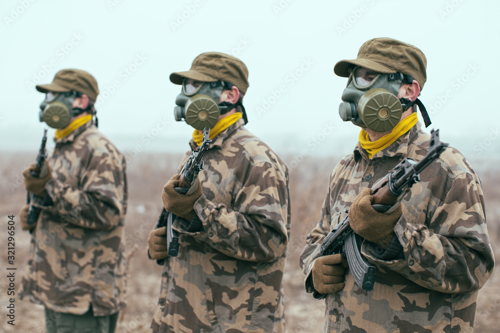 Soldiers with gas mask and automatic guns standing ready Soldiers with gas mask and automatic guns standing ready