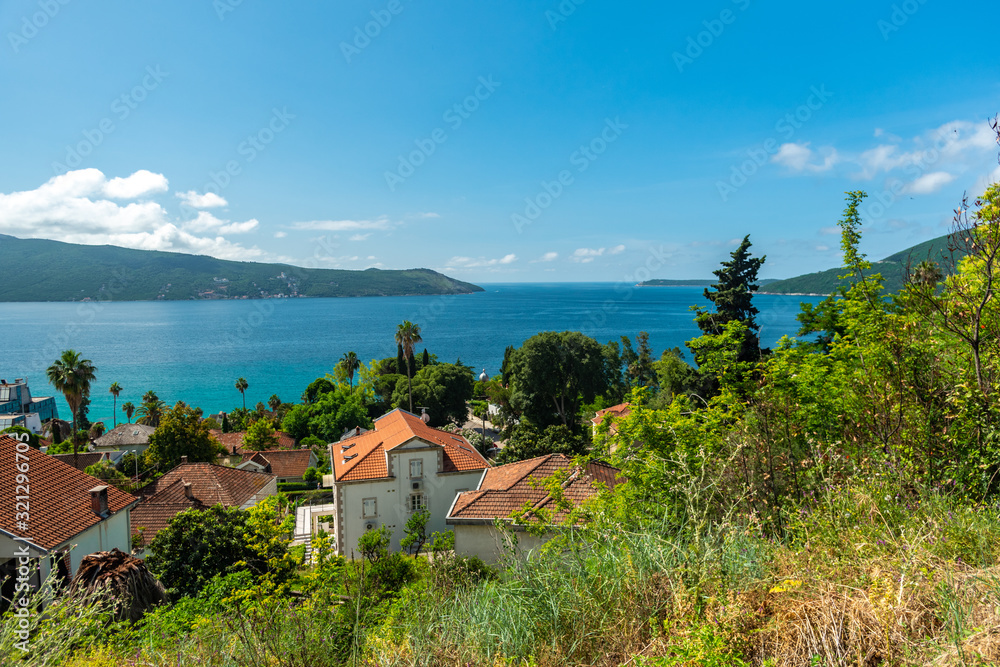 Seascape with tiled roofs of houses, yachts and forest. On a sunny day with blue sky. Seascape with tiled roofs of houses, yachts and forest. On a sunny day with blue sky.