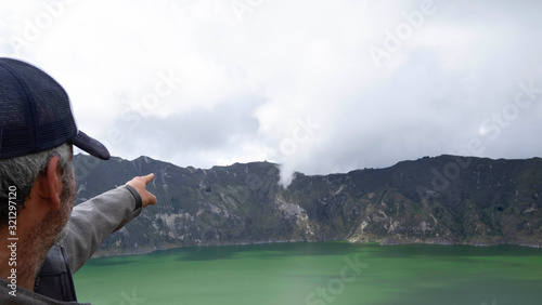 Quilotoa lagoon, Ecuador, man pointing out at fumarole photo