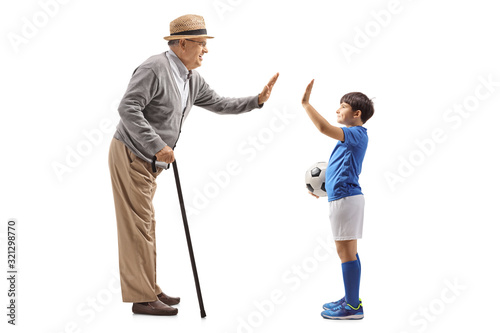 Grandson with a soccer ball gesturing high five with grandfather