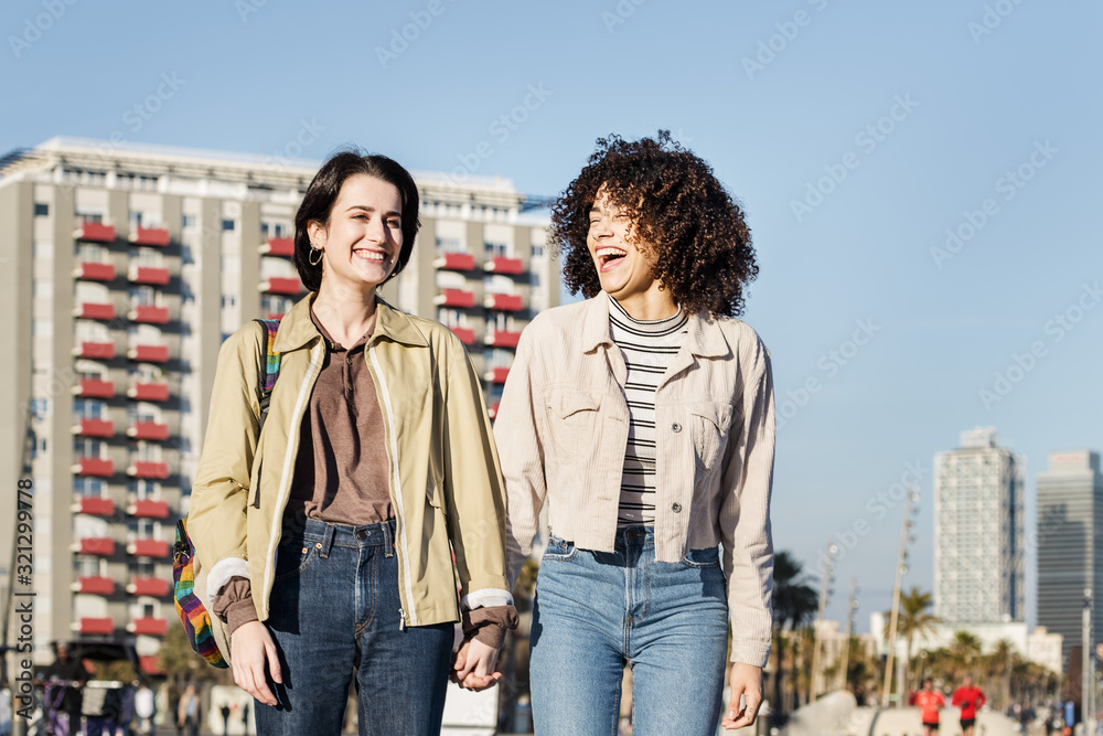 multiracial couple of women walking and laughing