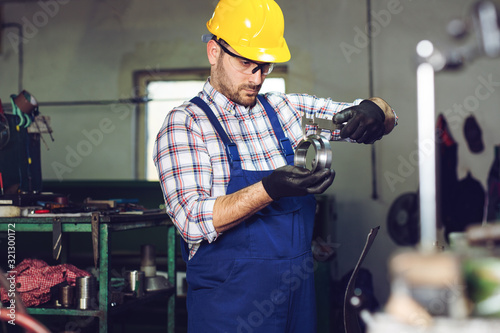 Mechanical technician measuring with caliper in workshop photo