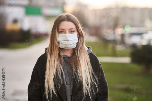 Girl in a medical mask on the background of the city. Coronavirus. Prevention of viral diseases photo