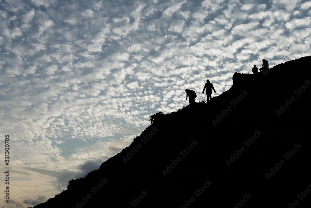 The silhouette of hikers on the hill during sunset