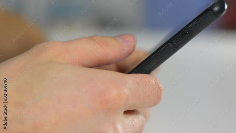 male hands click on smartphone screen in office male hands click on smartphone screen in office