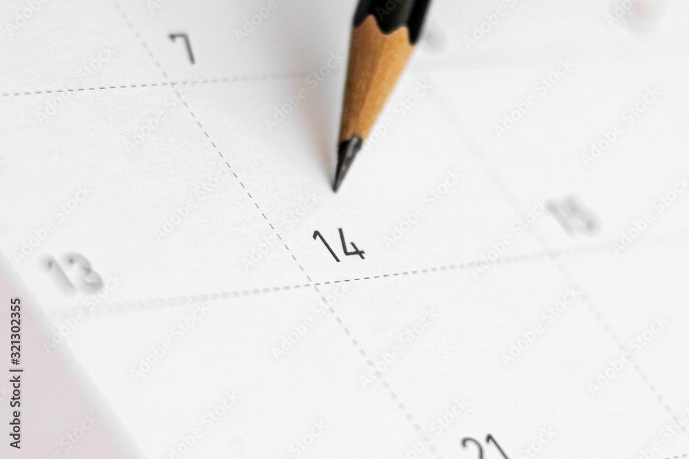 pencil point at date of february 14 on the calendar. - Valentine's Day concept. pencil point at date of february 14 on the calendar. - Valentine's Day concept.