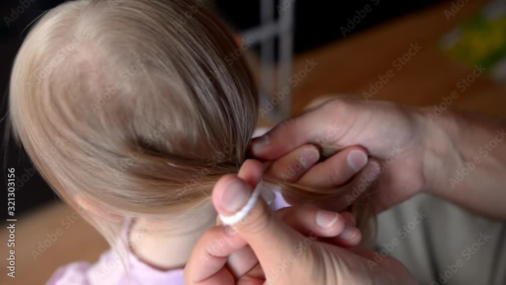 Father combs his daughter and puts a bow on her Father combs his daughter and puts a bow on her