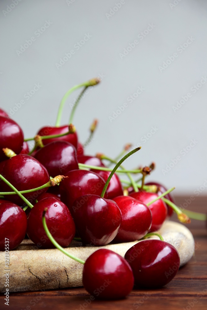 Rote Kirschen frisch geerntet auf einem Holzbrett und einem Holztisch, isoliert und freigestellt Rote Kirschen frisch geerntet auf einem Holzbrett und einem Holztisch, isoliert und freigestellt