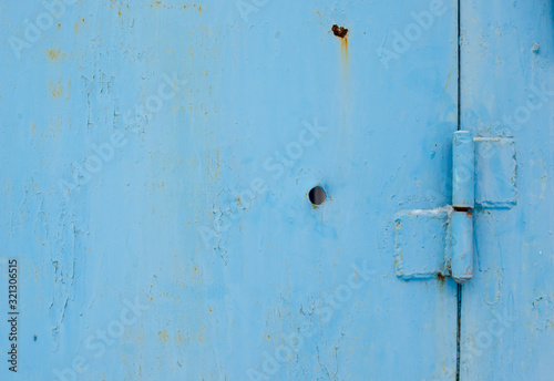 old blue metal door with a hole