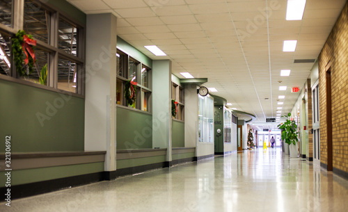 Empty hall in college decorated with Christmas wreaths. Perspective of hallway