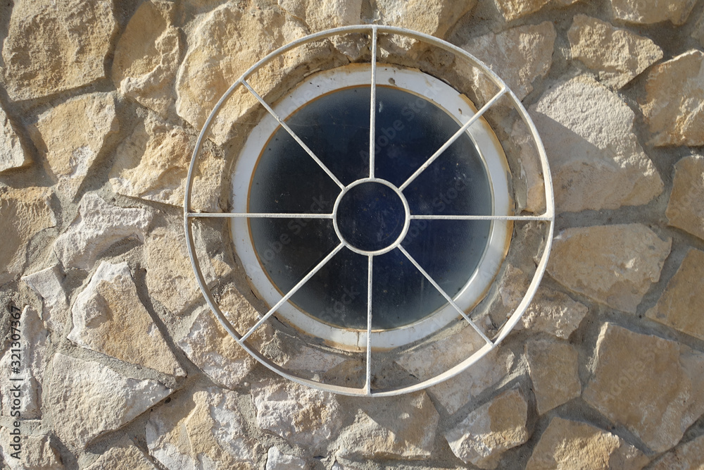 Round window with a circular metal grill
