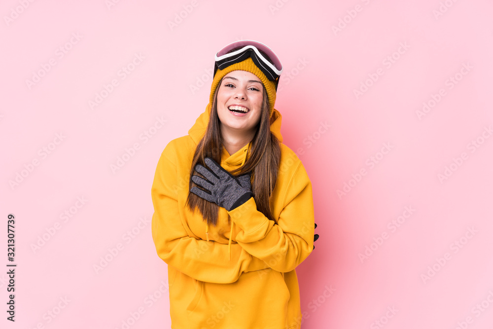 Young caucasian skier woman isolated laughs out loudly keeping hand on chest.