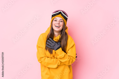Young caucasian skier woman isolated laughs out loudly keeping hand on chest.