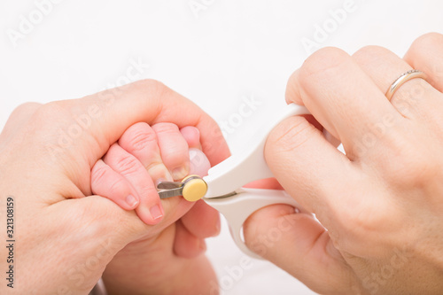 Mother cuts newborn baby fingernails
