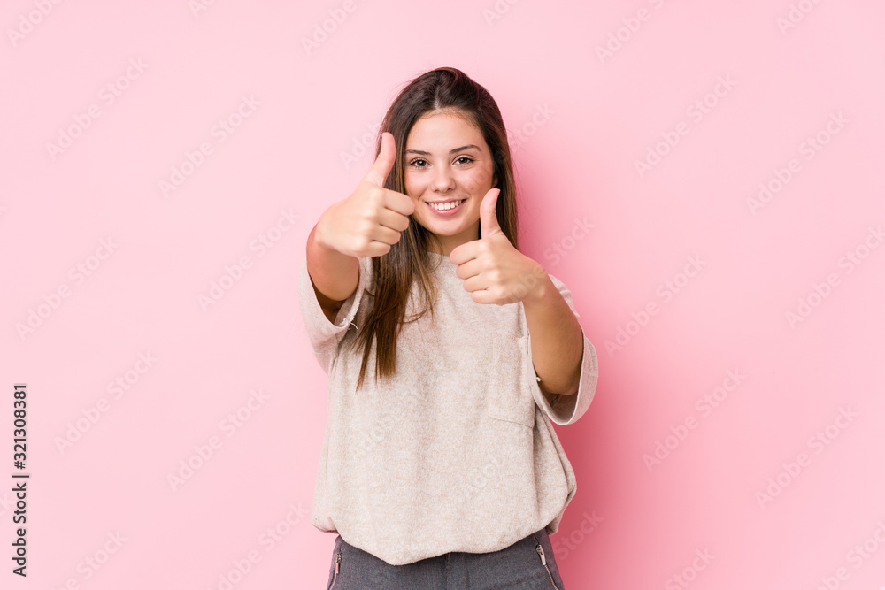 Young caucasian woman posing isolated with thumbs ups, cheers about something, support and respect concept. Young caucasian woman posing isolated with thumbs ups, cheers about something, support and respect concept.