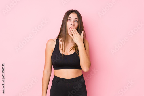 Young fitness caucasian woman isolated yawning showing a tired gesture covering mouth with hand.