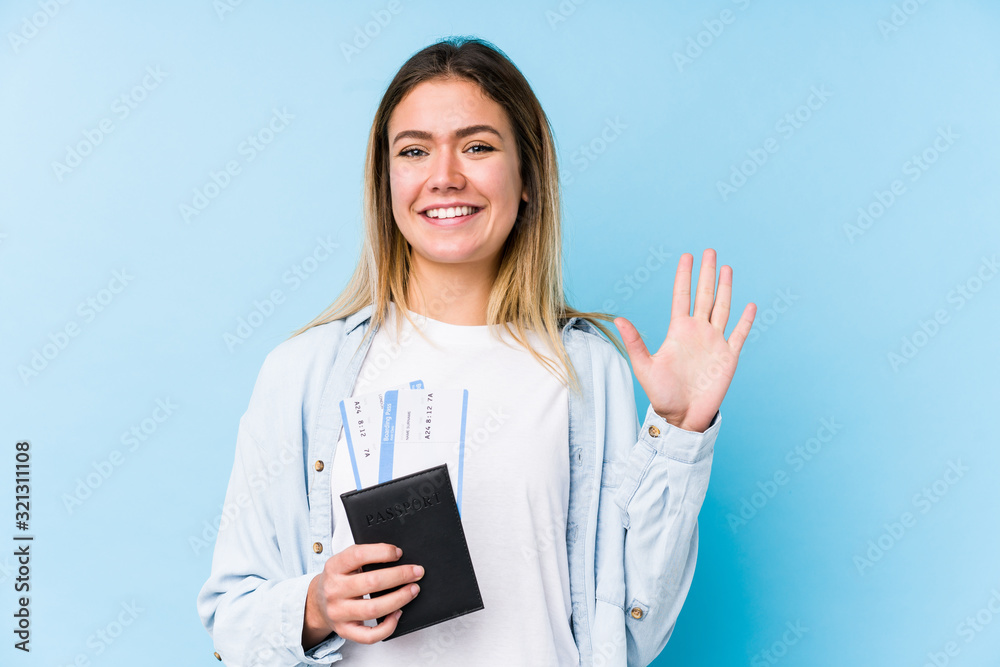 Young caucasian woman holding a passport isolated smiling cheerful showing number five with fingers. Young caucasian woman holding a passport isolated smiling cheerful showing number five with fingers.