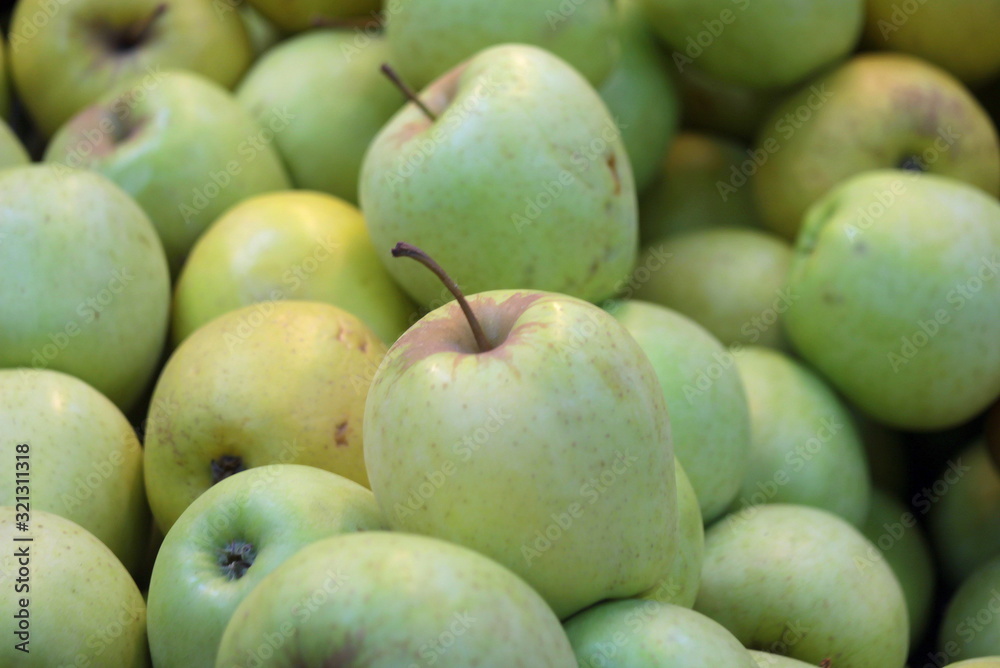 Green juicy apples lie on a store counter. Green juicy apples lie on a store counter.